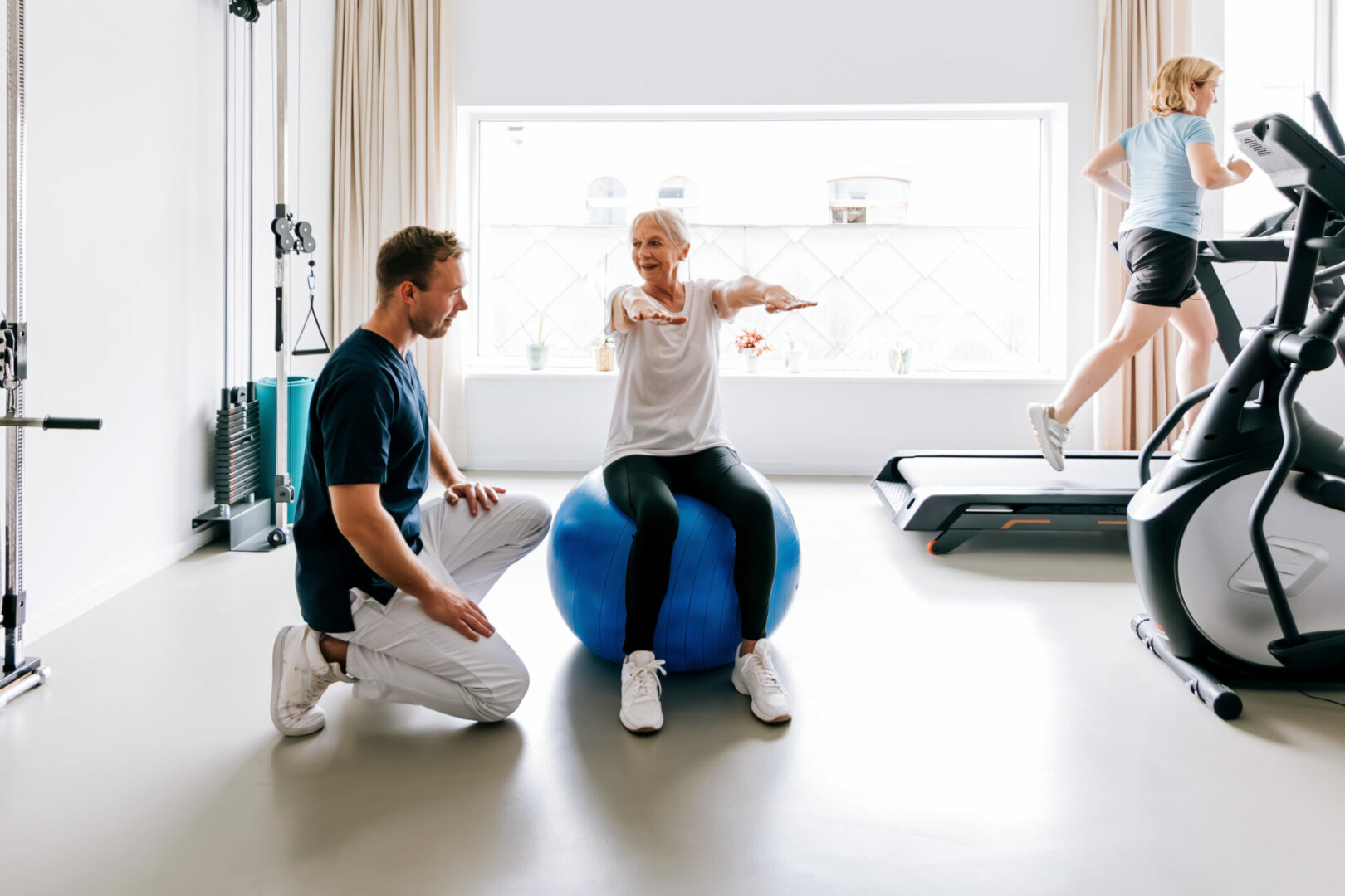 People in a physiotherapy clinic do remedial gymnastics with the specialist